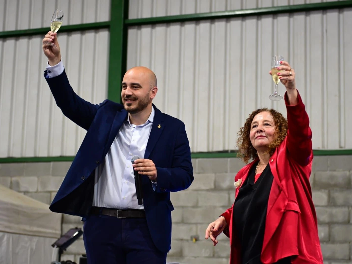 El alcalde y la regidora Isabel Marcos brindando desde el escenario durante el homenaje a la Gent Gran