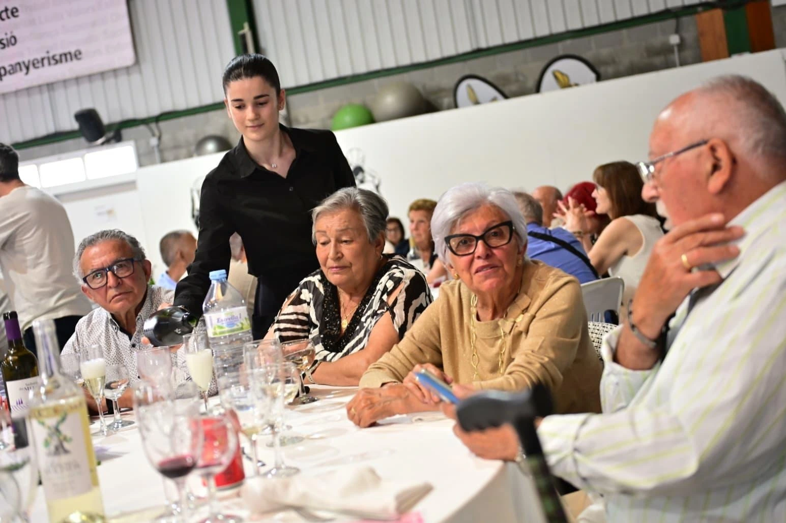 Vista general de la comida con las mesas llenas de Gent Gran disfrutando de la jornada en el Poliesportiu Josep Pla